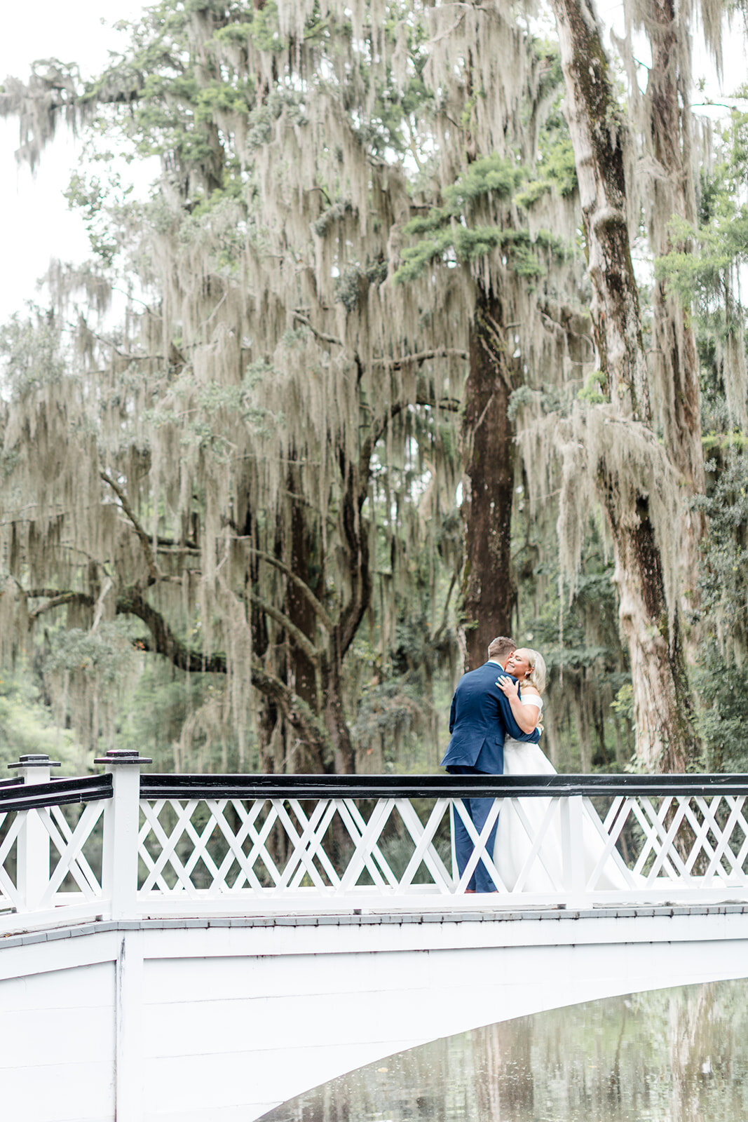 Bride and groom hugging on bridge at Magnolia Plantation; Charleston, South Carolina