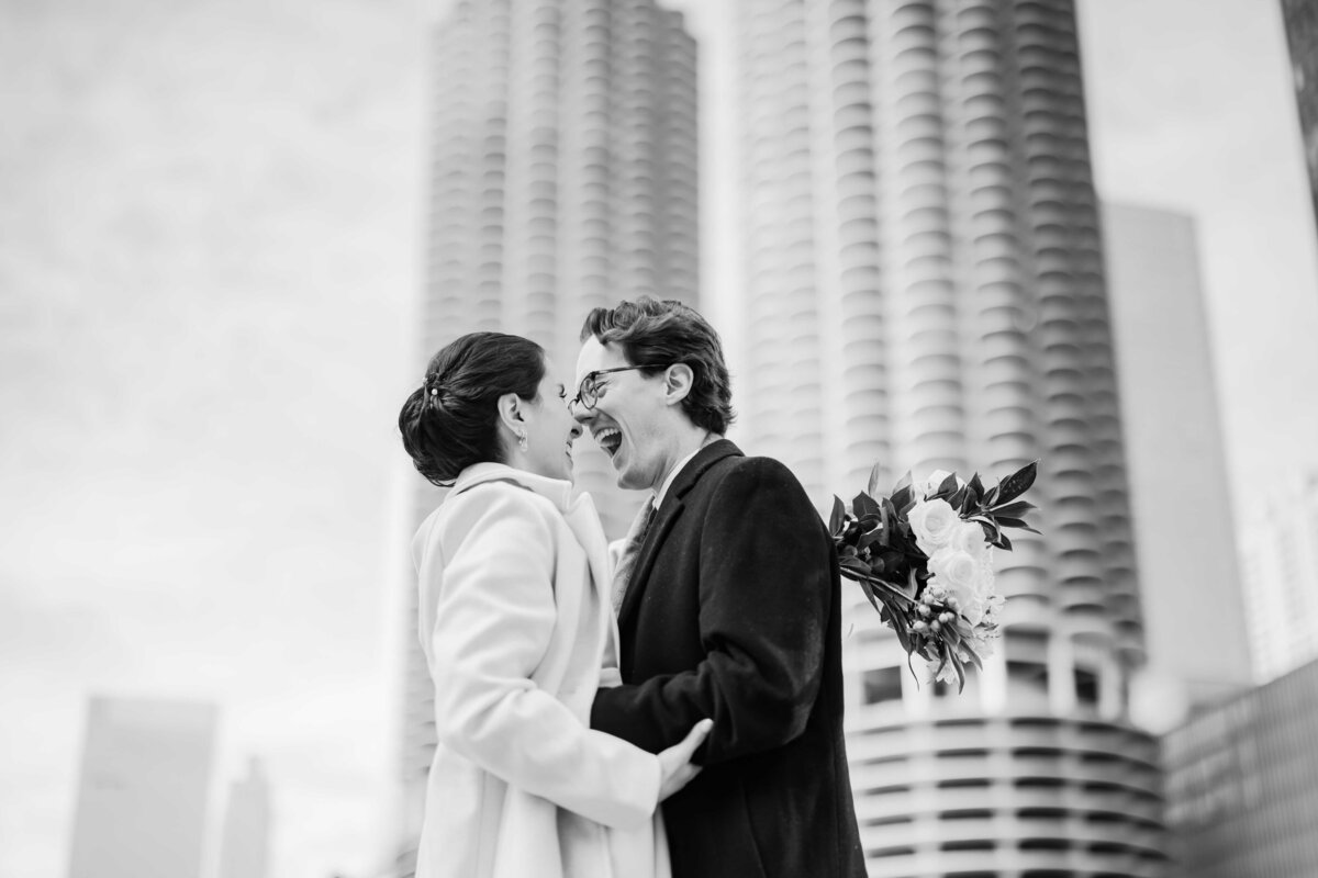 Bride and groom laugh in front of Marine Tower in Chicago