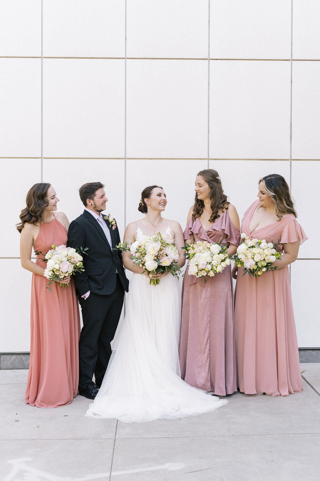 bride with bridesmaids and bridesman looking at each other