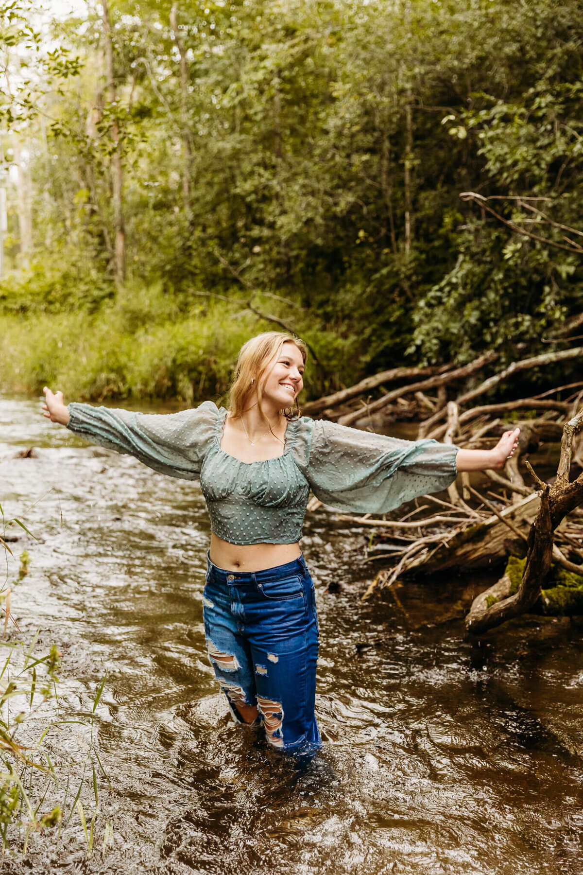 high school girl standing in a creek during her photo session