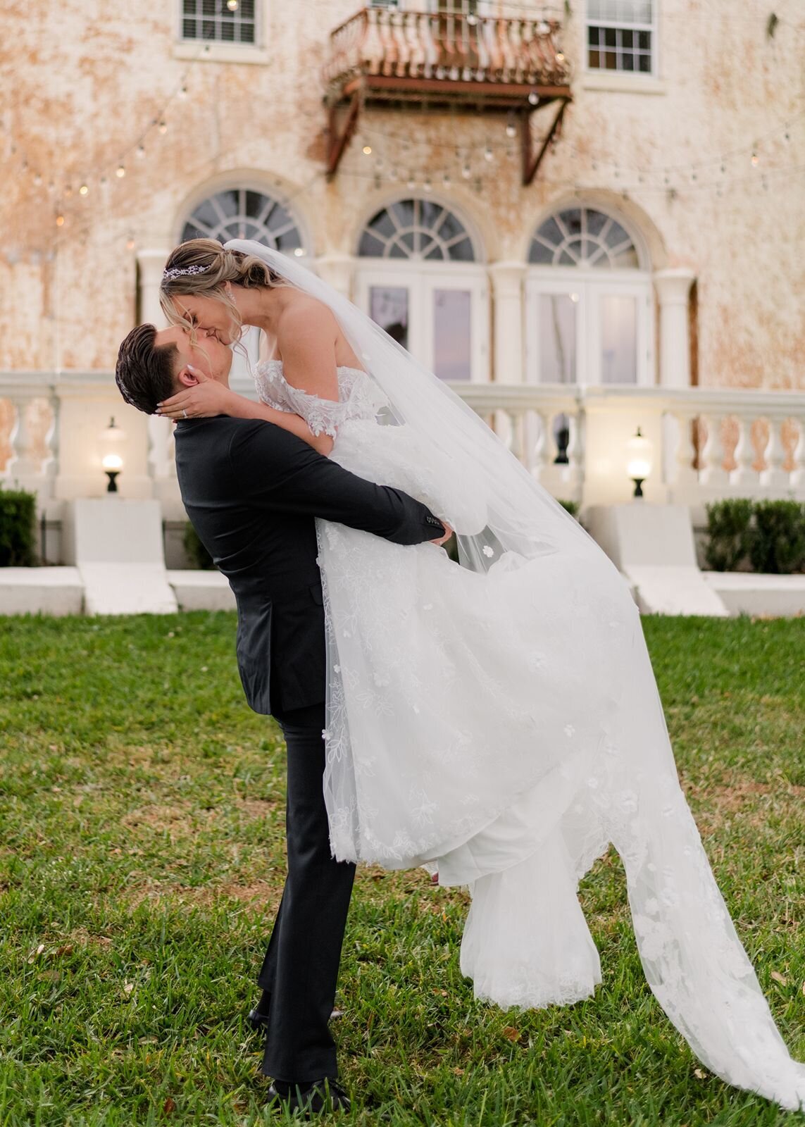 Groom lifting bride with kiss at Bella Cosa, Lake Wales, Florida