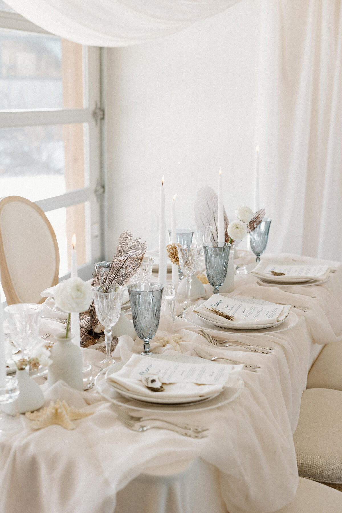 A close up of the guests' white-themed tableware for the reception