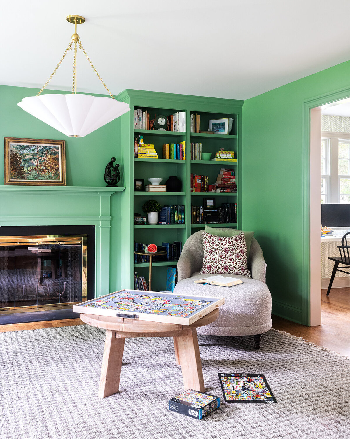 green living room with open shelves and built-in fire place