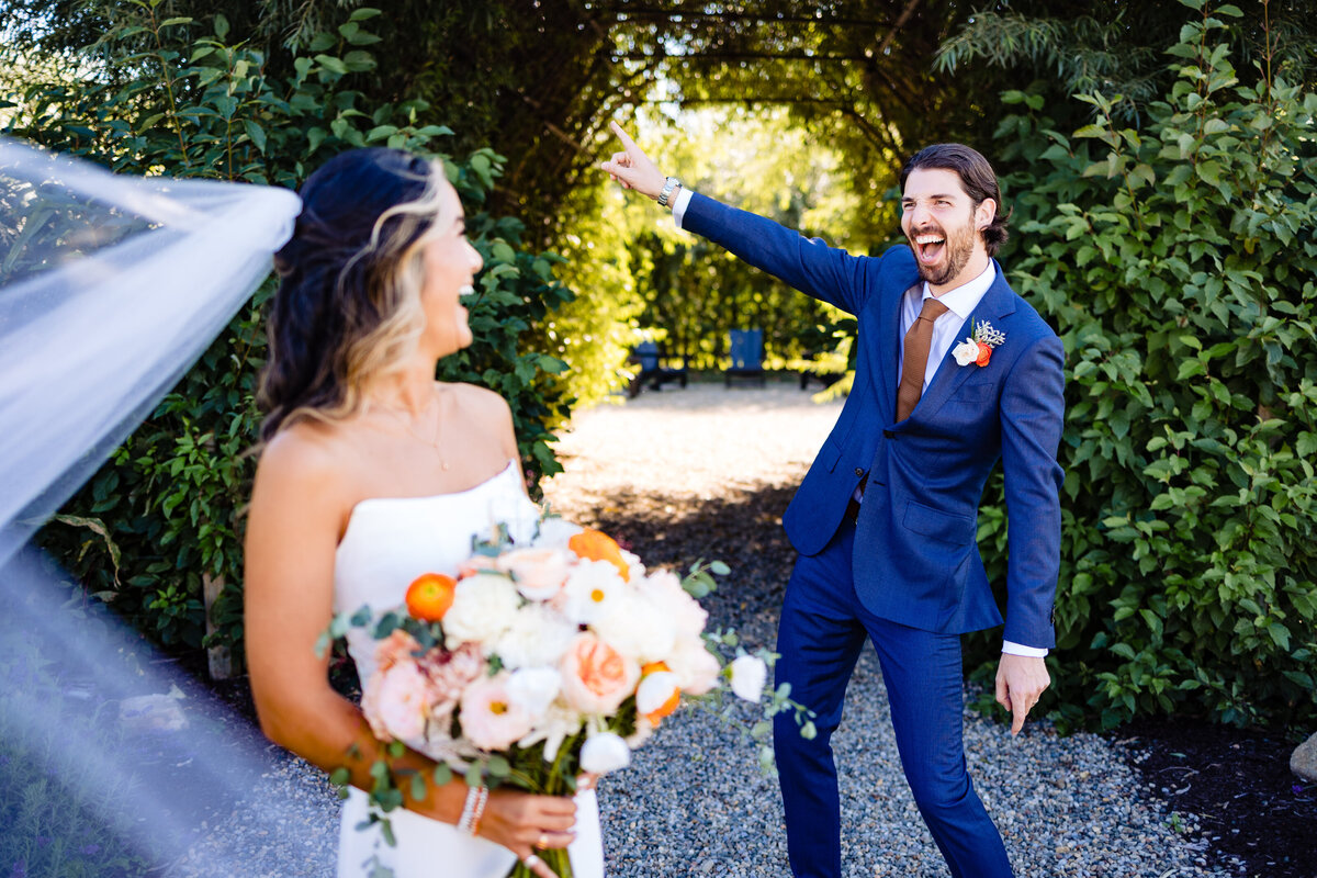 A bride laughs in the foreground as her groom breaks out his best dance move in a garden in Toledo