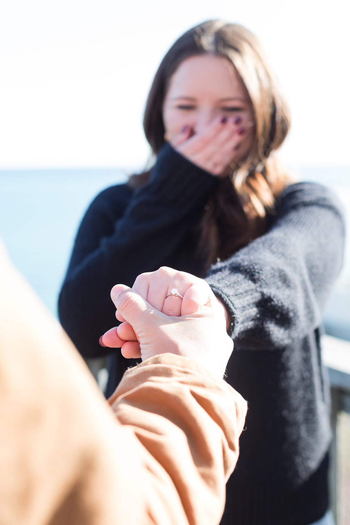 Engaged couple looking at ring and smiling