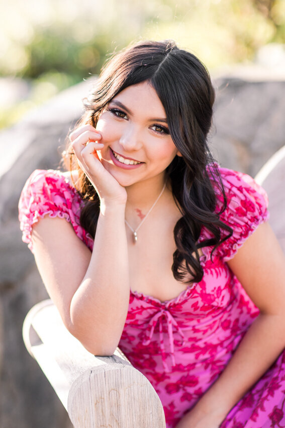 teen girl in pink dress sitting on bench