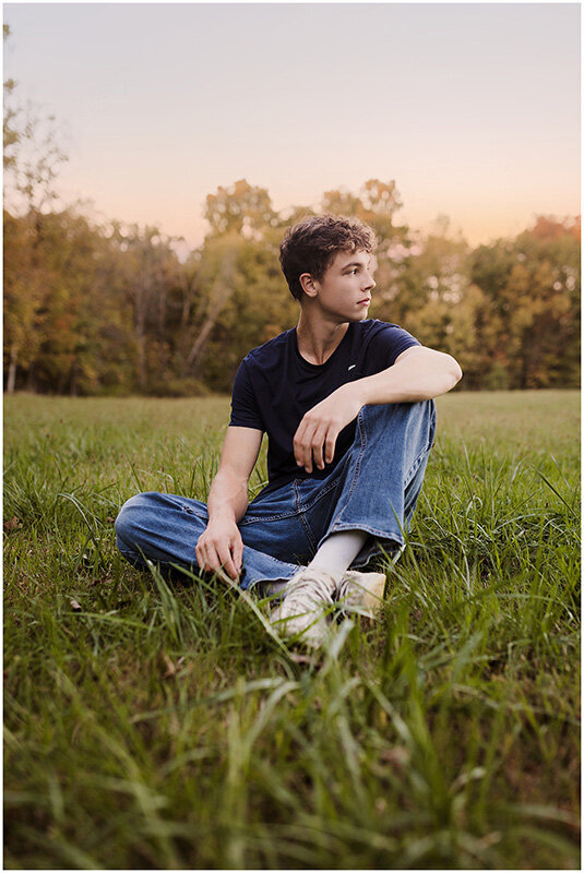 Senior boy sitting in a field