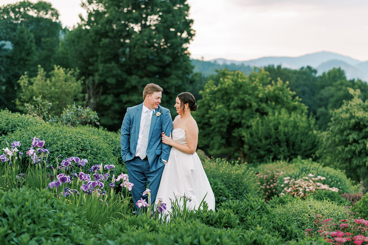 Bride and groom smiling during romantic portrait session outdoors at a summer mountain wedding in Cashiers, North Carolina.