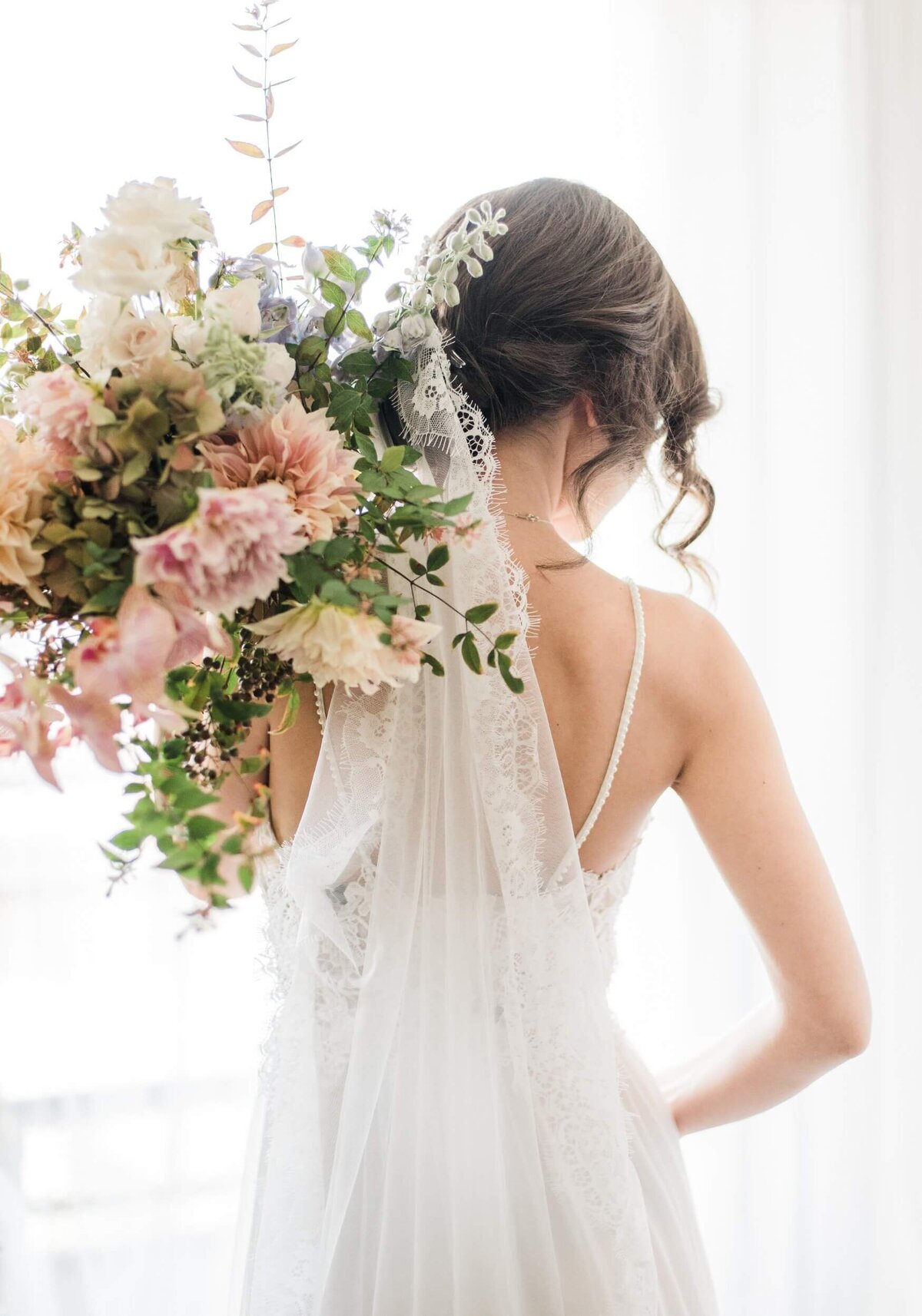 Woman in White Floral Wedding Dress Holding Bouquet of Flowers