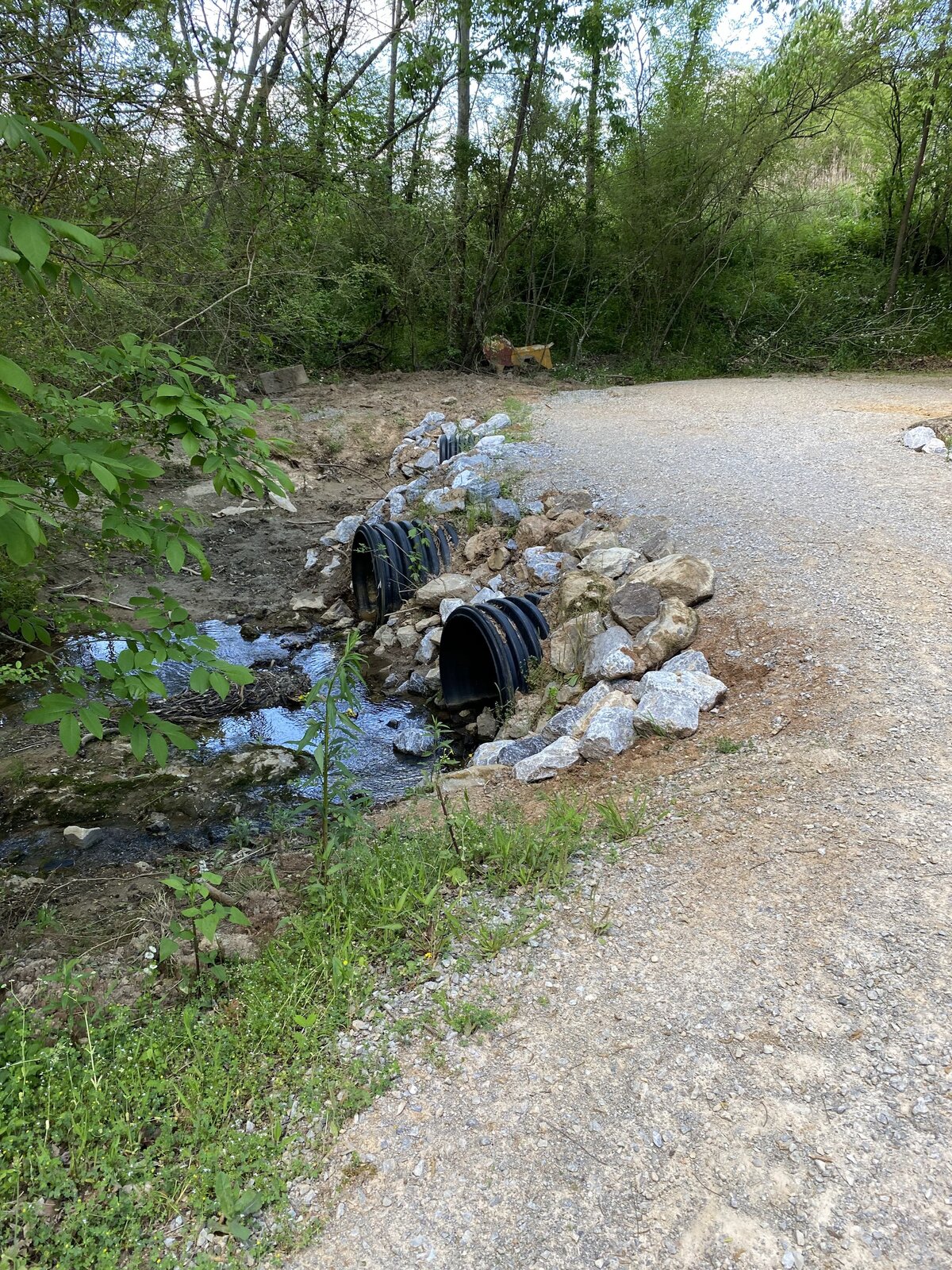 water-coming-out-of-two-large-pipes-under-gravel-road