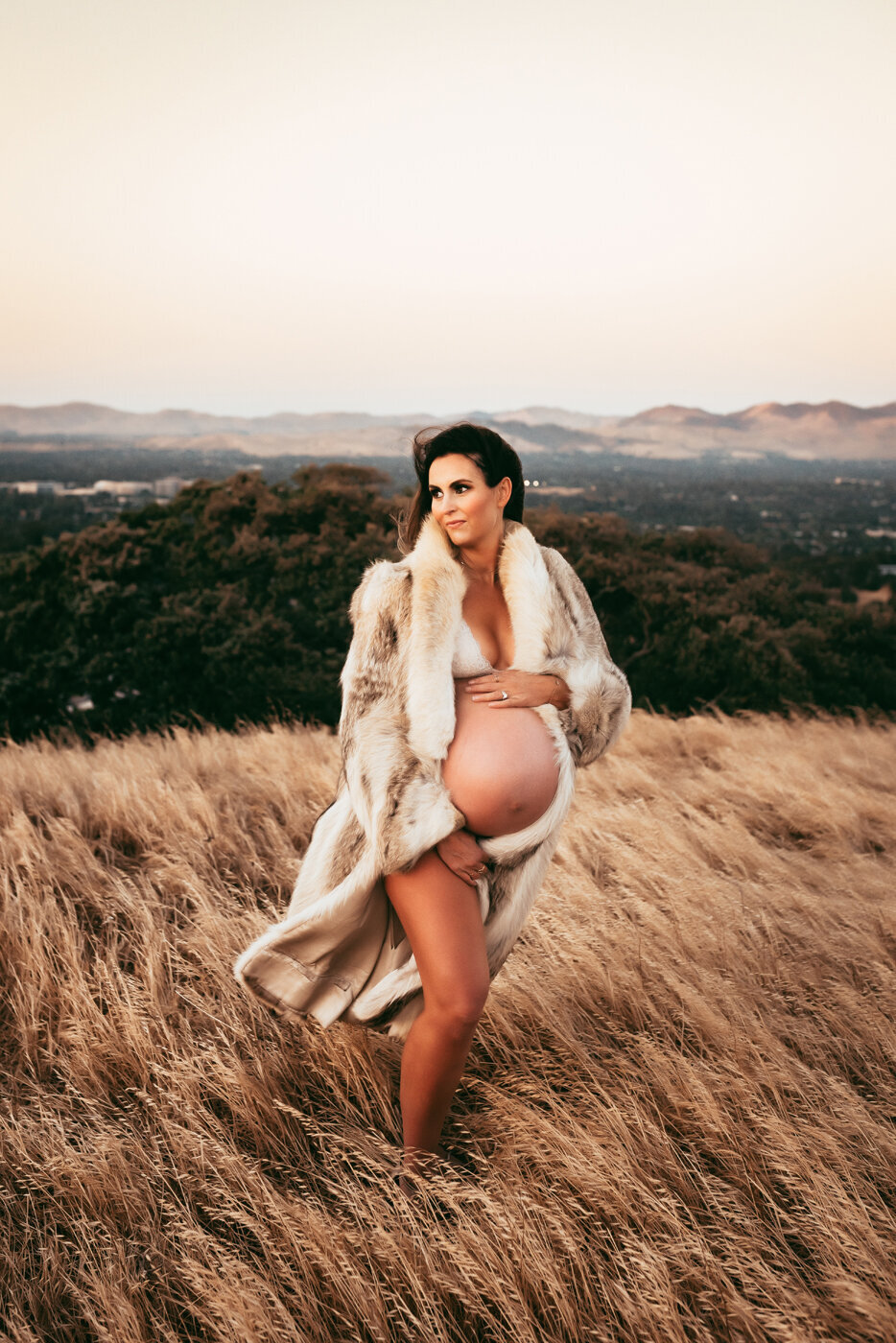 Maternity session with mama wearing a fur coat and showing her baby bump
