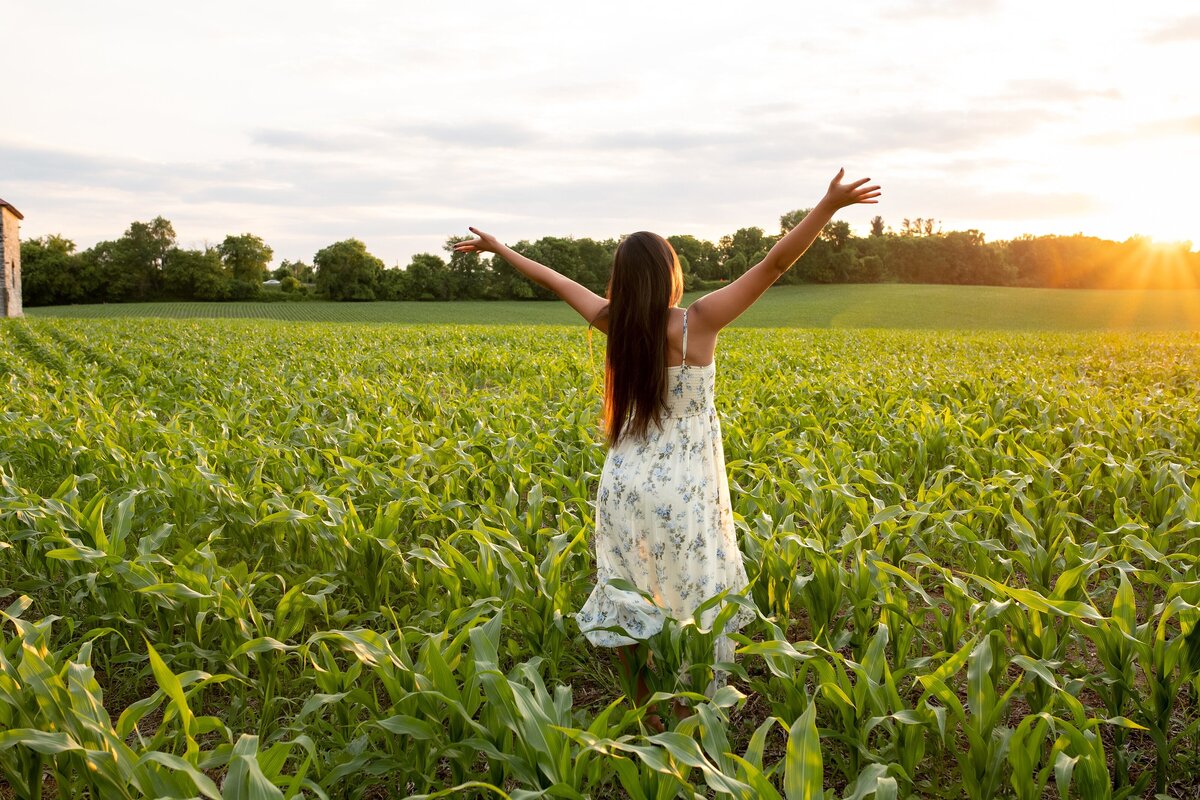 girl in cornfield with sunset