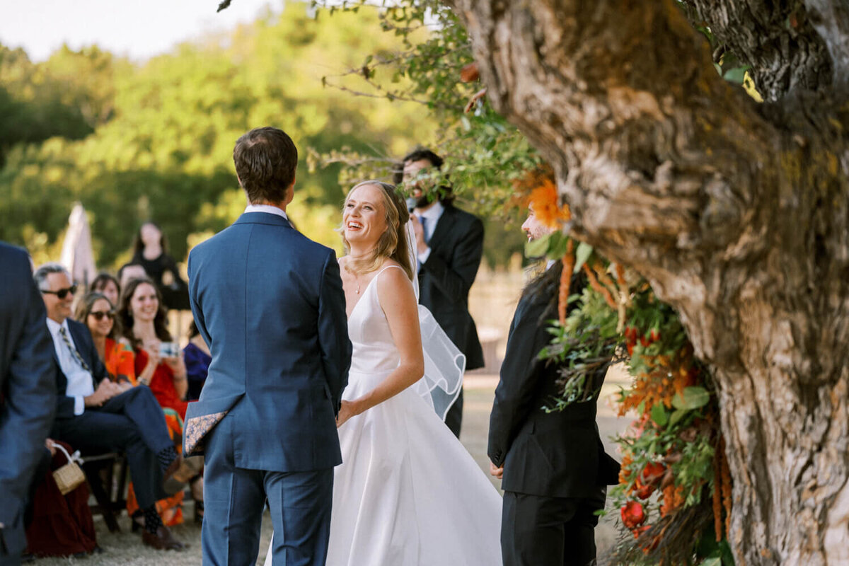 bride-looking-at-groom-during-ceremony-laughing