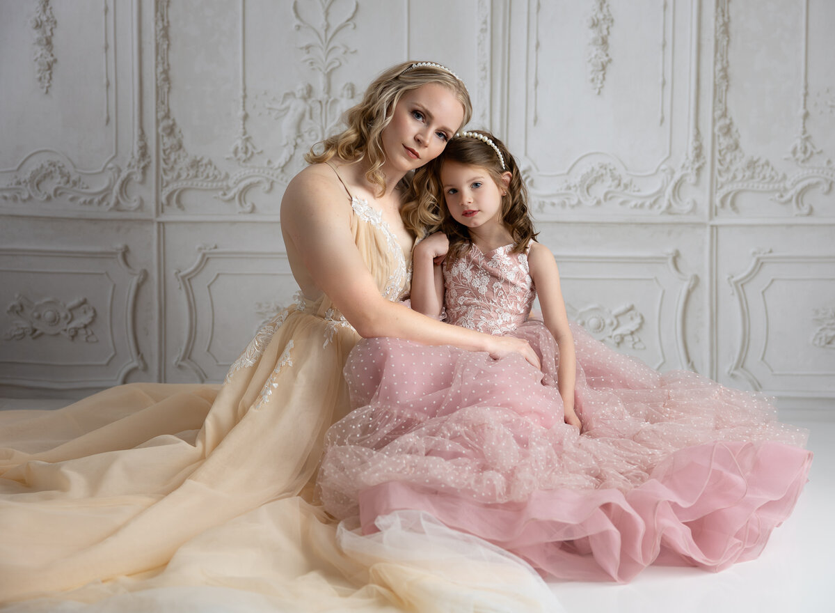 Mother and young girl in cream and pink couture dream dresses during fine art session