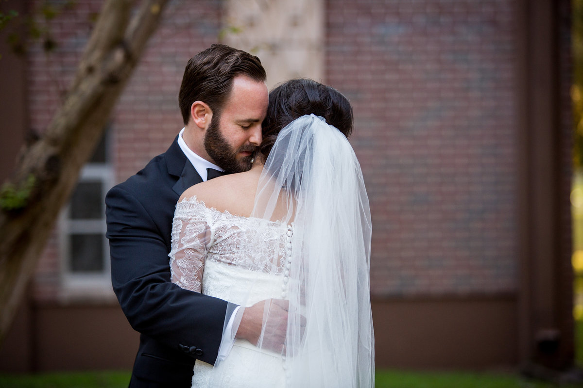 groom pulls his bride in close after first look at Immaculate Conception Chapel and Oblate wedding venue in San Antonio