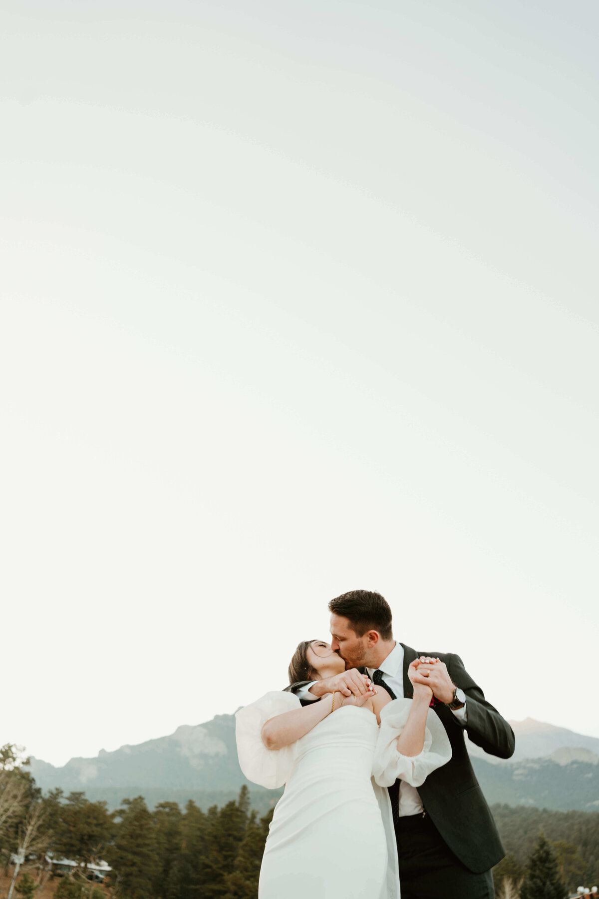 Groom Kissing Bride With Clear Sky Background