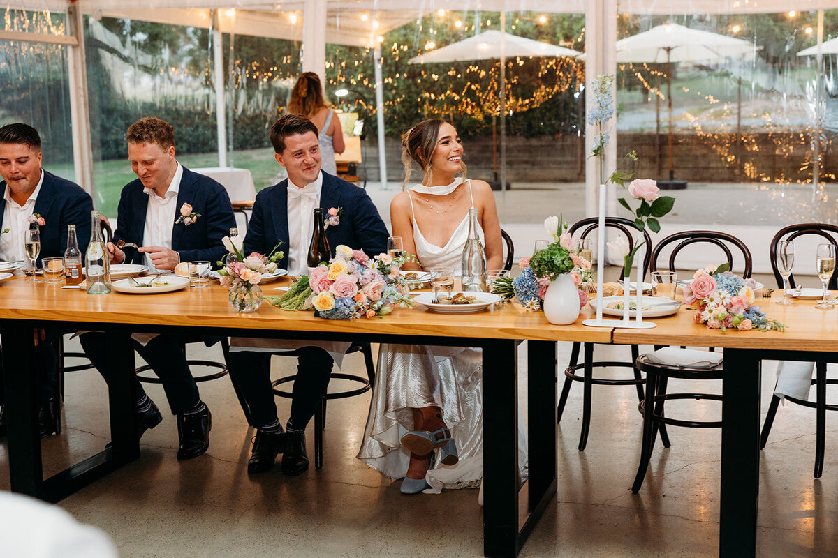 Bride and groom laughing during wedding speeches