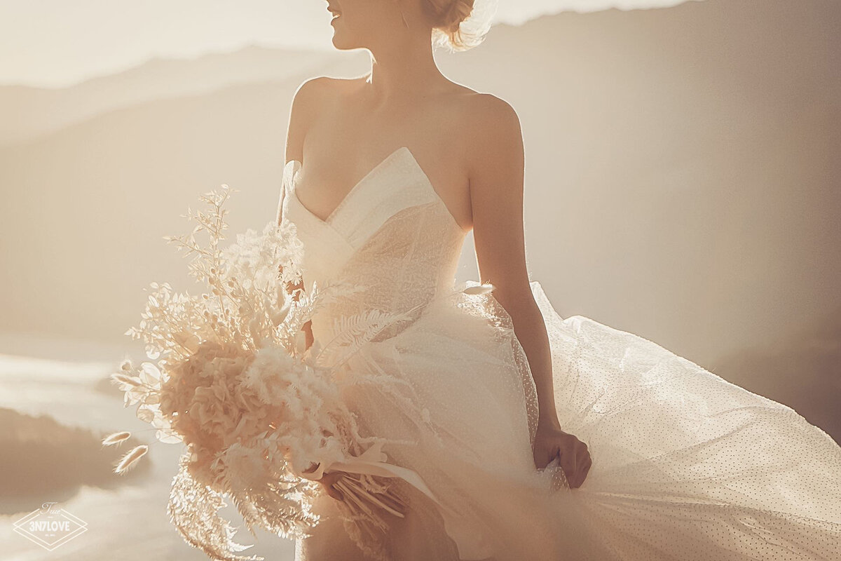 A sunkissed bride holding a bouquet.