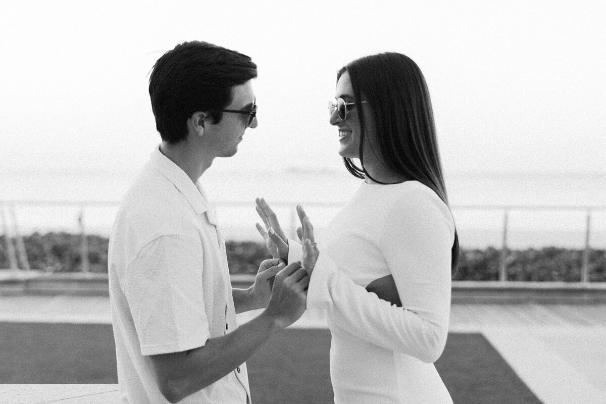 Captured in a heartfelt black and white moment, Rebecca and Graysen hold hands and share a deep conversation during their romantic engagement session at Marriott Hotel Fort Lauderdale.