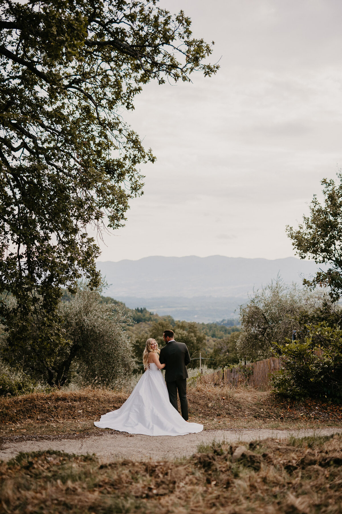 Bride and groom with Tuscan hills view at Ristonchi Castle, elegant wedding photographer Florence Tuscany.