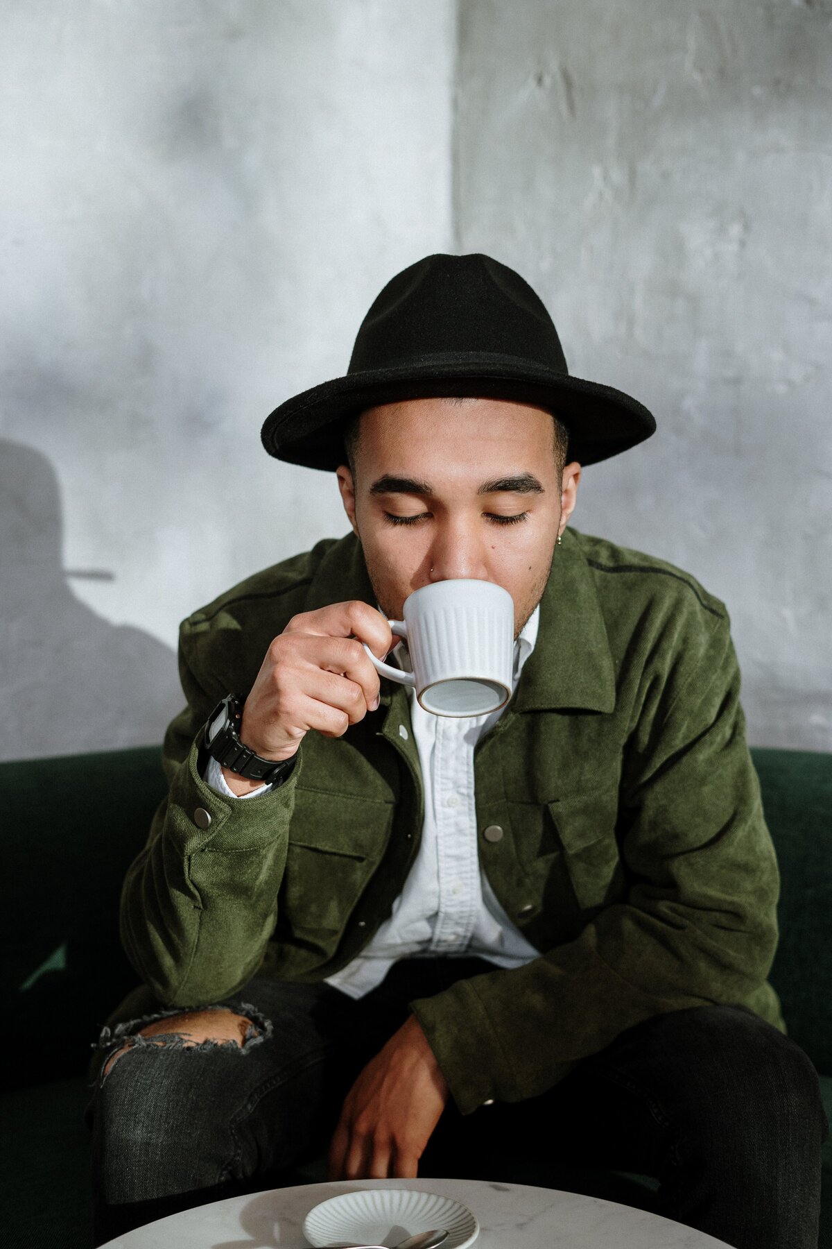 man-in-green-jacket-drinking-from-white-ceramic-mug-4255408