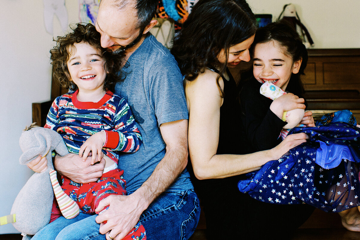 a family sits on a bench and laughs