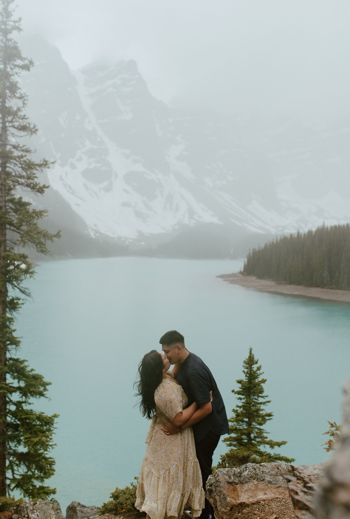 couple kissing in the rain at Moraine Lake, Alberta