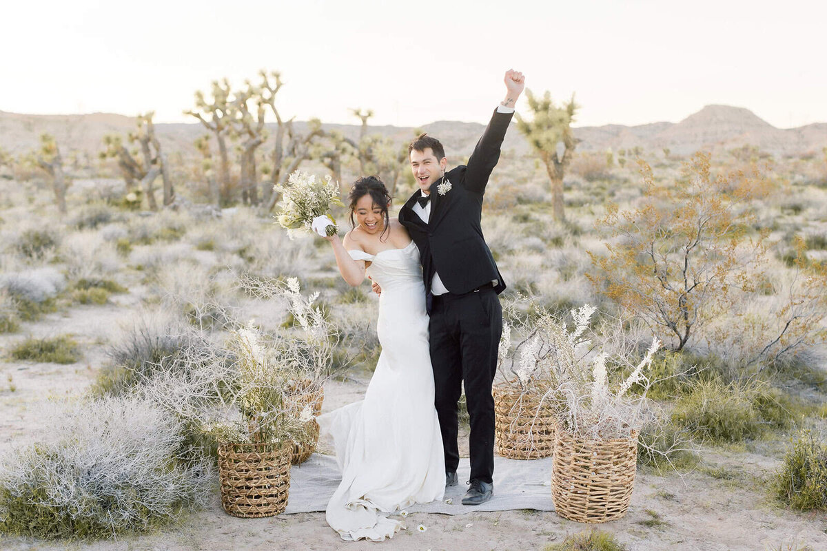 A groom wipes his eyes while exchanging vows with his bride while atop Taft Point with the view of Yosemite falls in the background at Yosemite National Park. 