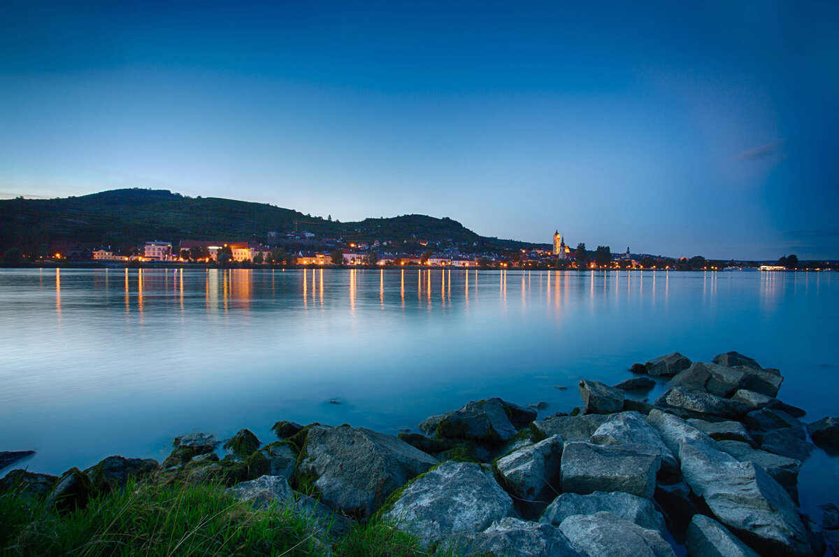 Ruhige Abendstimmung am Donauufer in der Wachau bei blauer Stunde – fotografiert vom Spezialisten für Alpenlandschaften, Atelier Schulte. Professionelle Landschaftsfotografie mit Fokus auf natürliche Lichtstimmungen in Österreich.