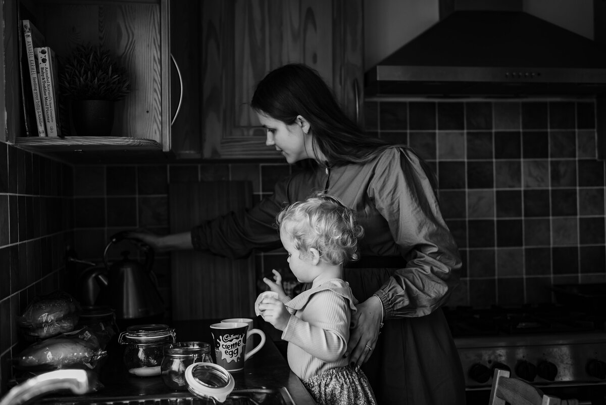 At home family photoshoot little girl helping her mum make a cup of tea