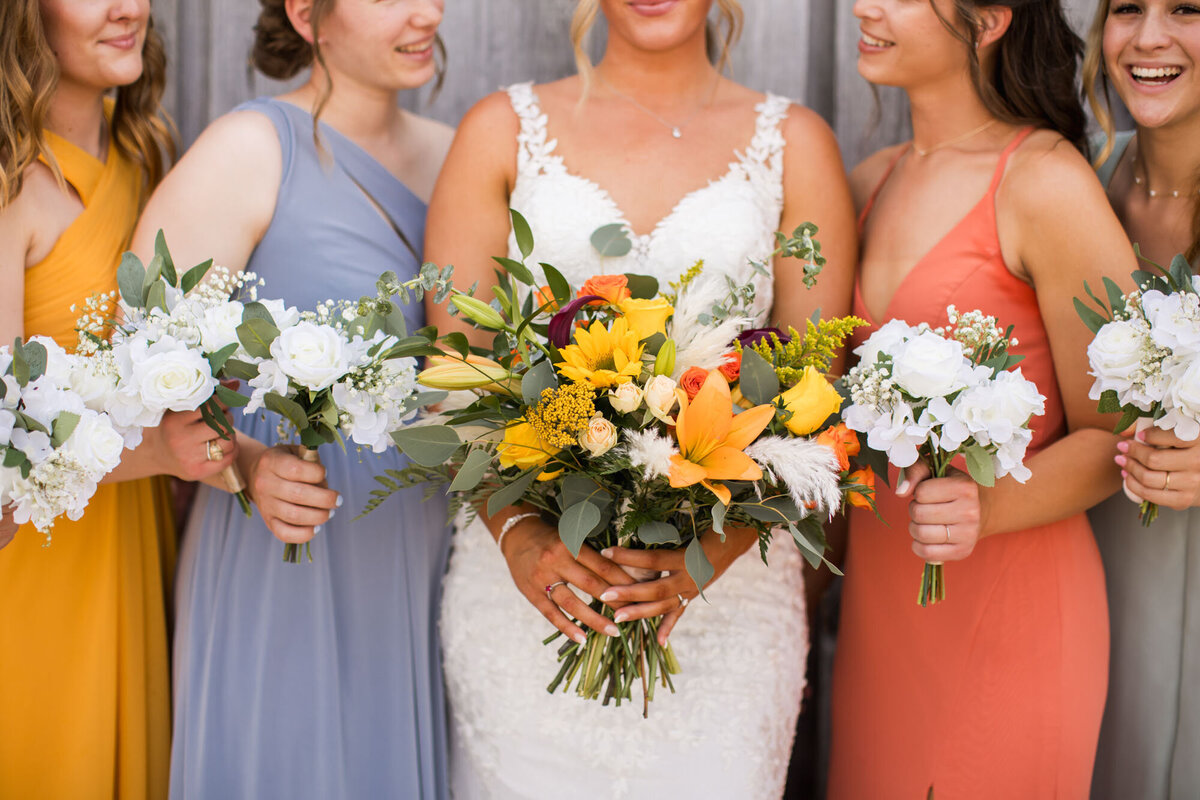 Bride holding colorful bouquet with bridesmaids
