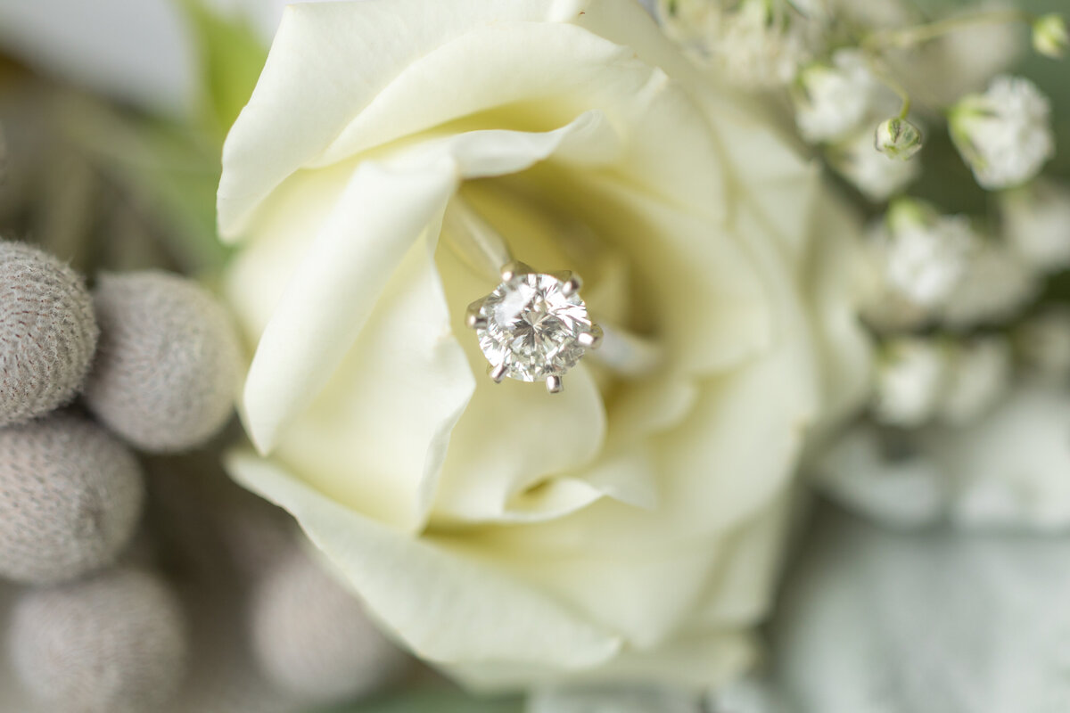 close-up of engagement ring and wedding flowers