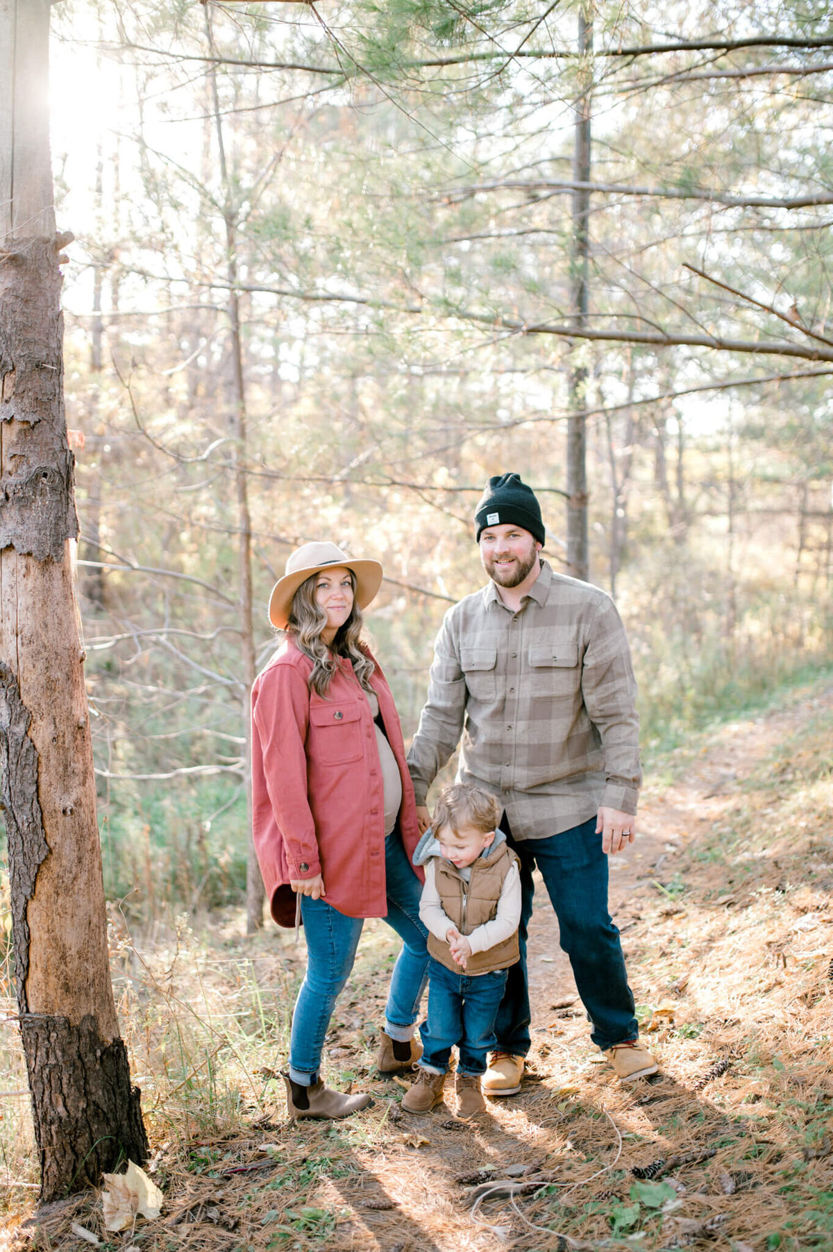 Family on a path in the forest. Light and airy family photography.