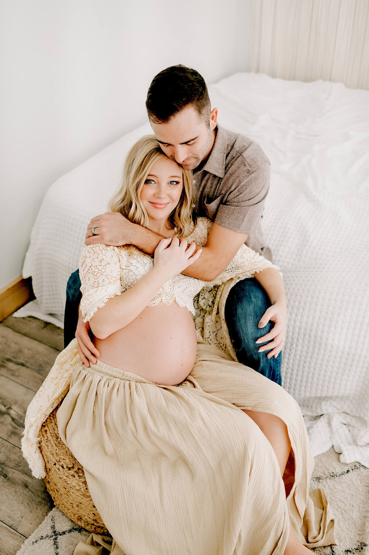 maternity photo in Springfield MO of pregnant mom smiling while husband cuddles baby bump