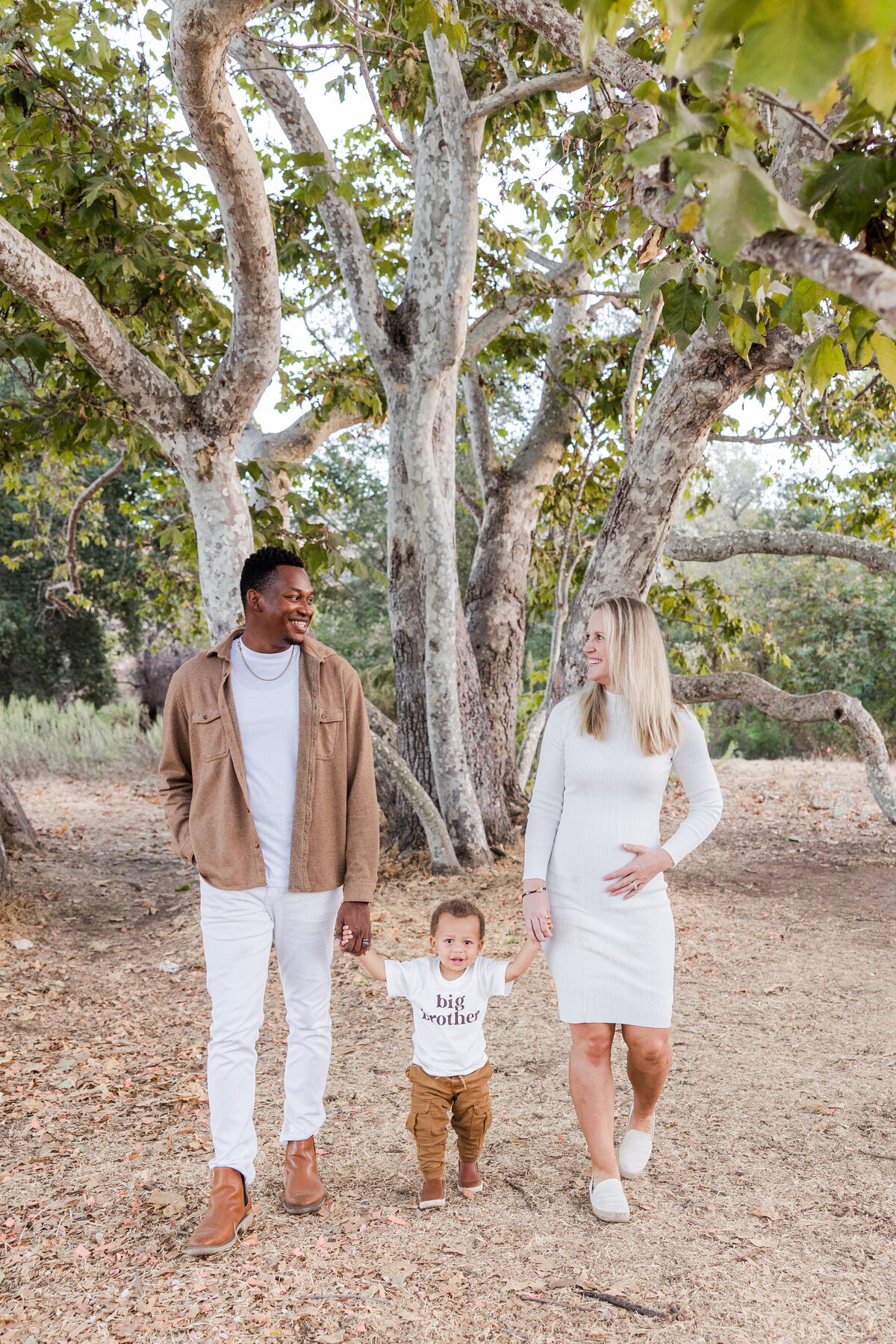 family holding hands walking under tree san diego