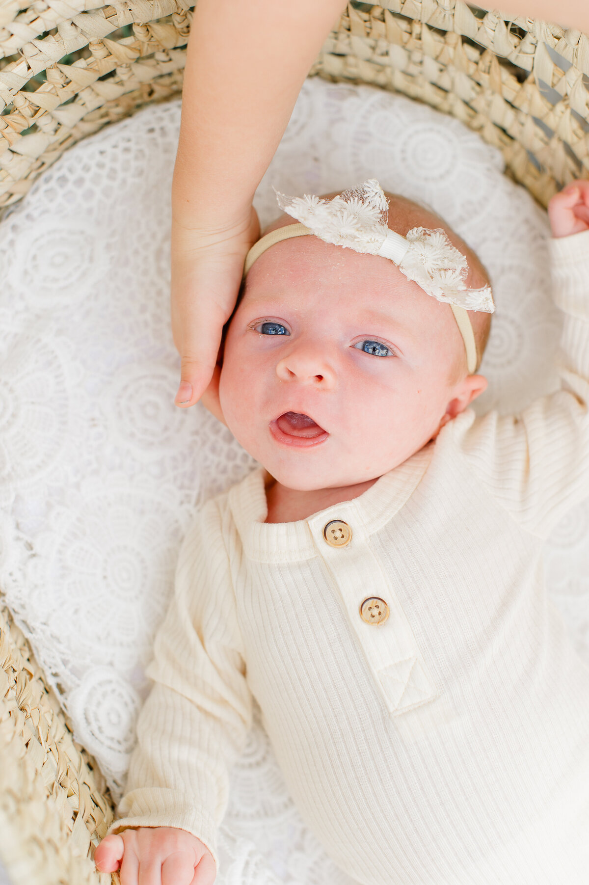 Beautiful blue eyed newborn baby girl looking into the camera during a newborn photo session with Orlando Newborn Photographer