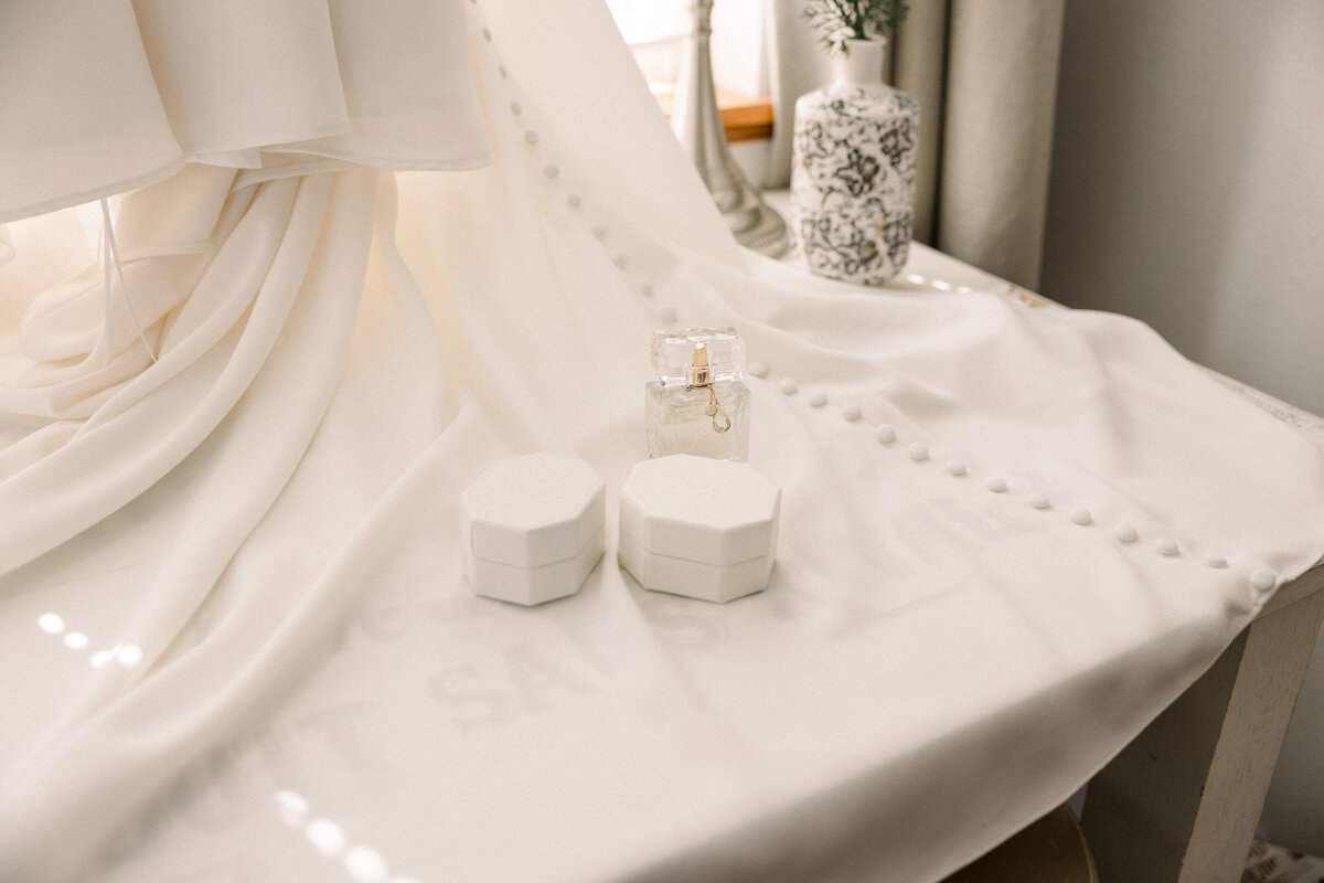 detail picture of jewerly boxes and perfume on wedding dress
