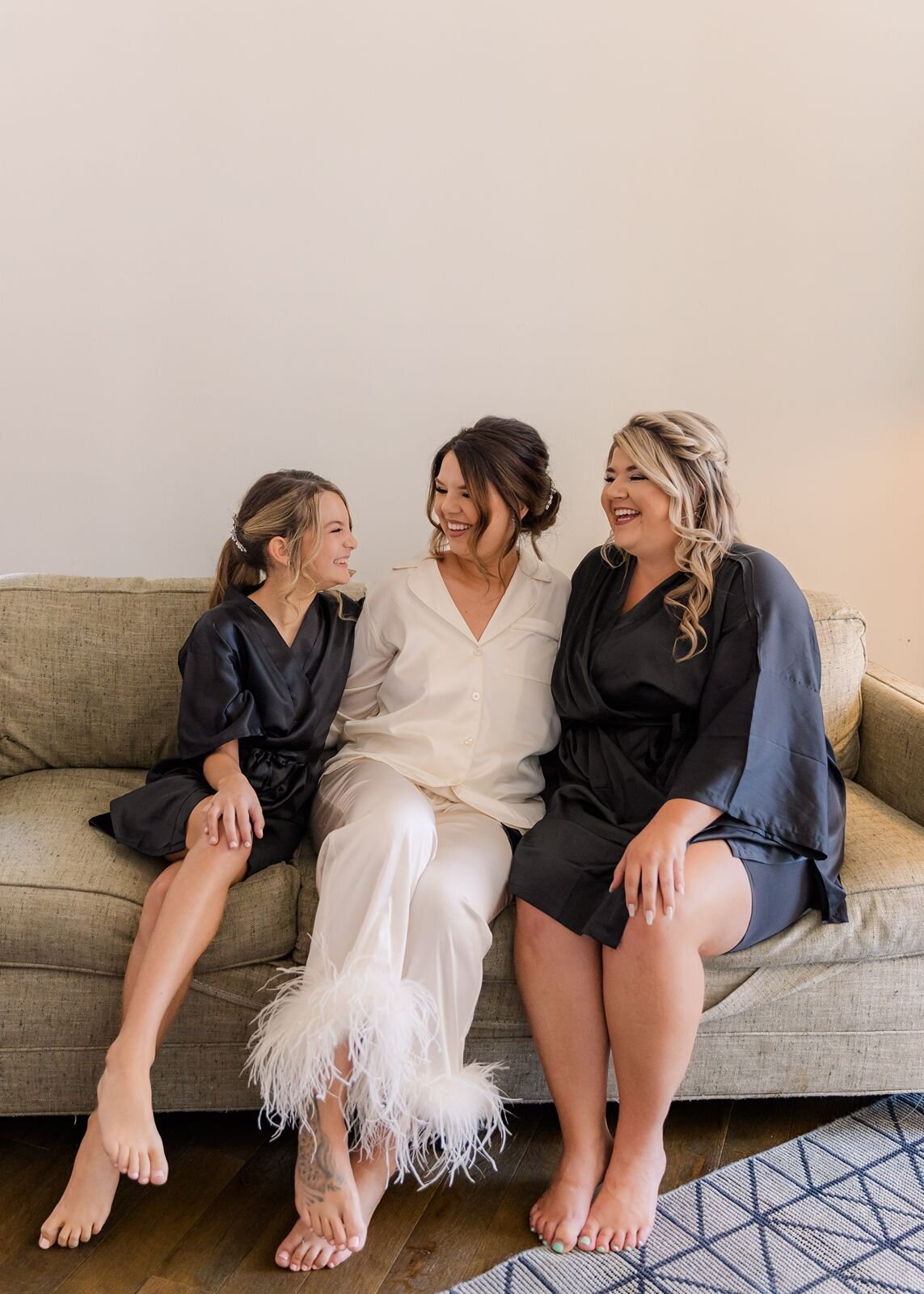 Bride with Bridesmaids  in  robes on couch  getting ready Savannah Georgia