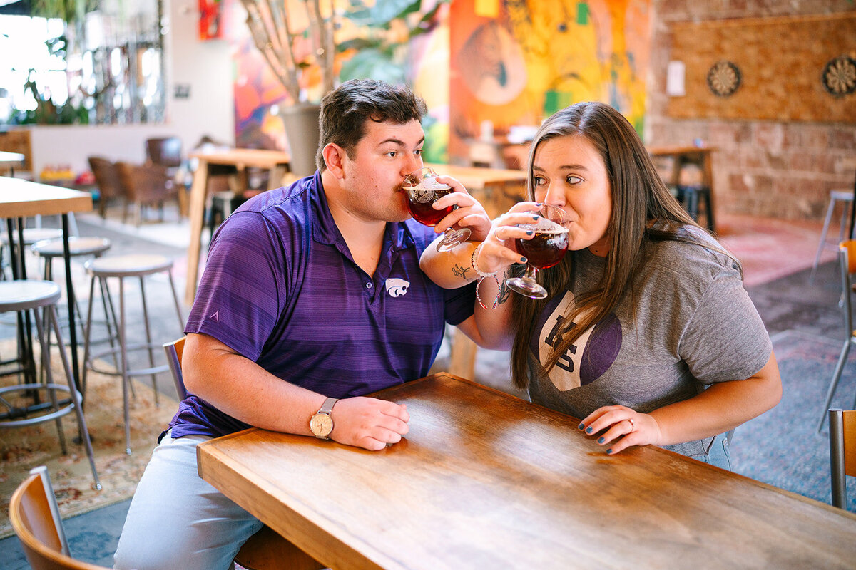 A couple linking arms and sipping drinks together 