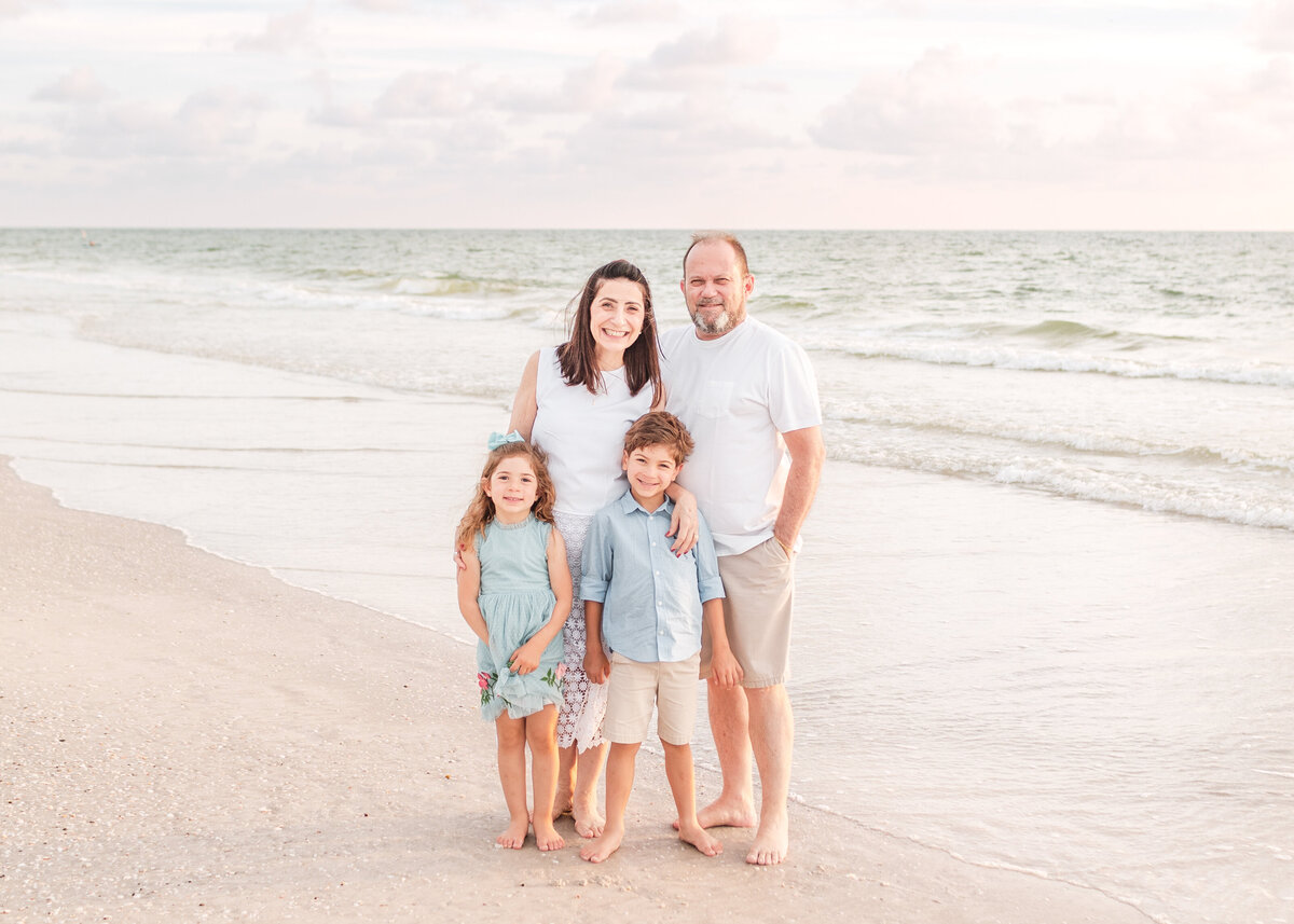 Extended family walking hand in hand along Clearwater Beach at sunset.
