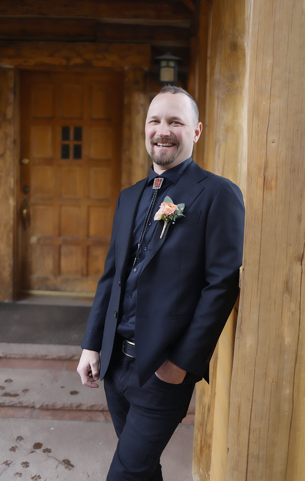 A handsome groom looks happy and ready to get married in Aspen, Colorado.