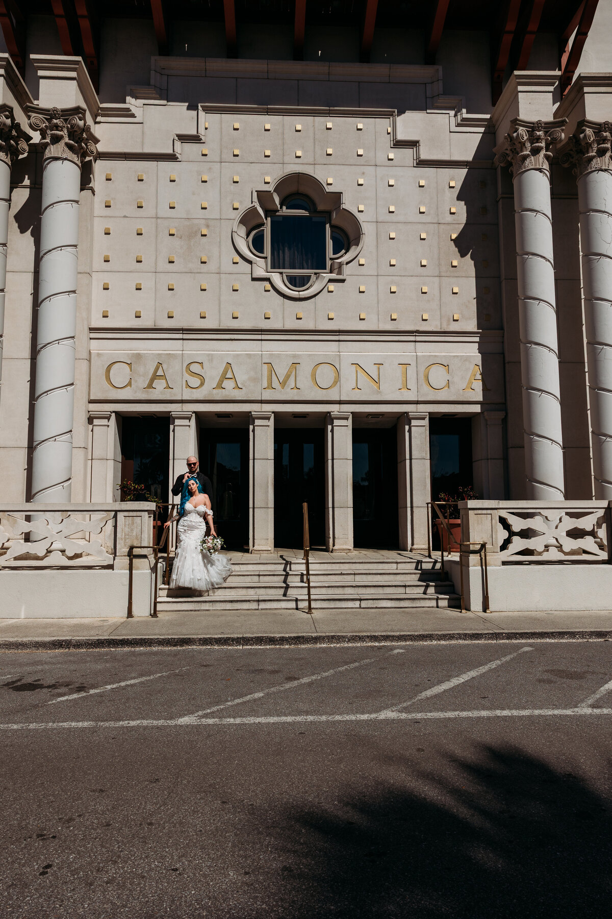 Bride and groom descend the steps of Casa Monica hotel in St. Augustine after their intimate, rock-and-roll inspired elopement.