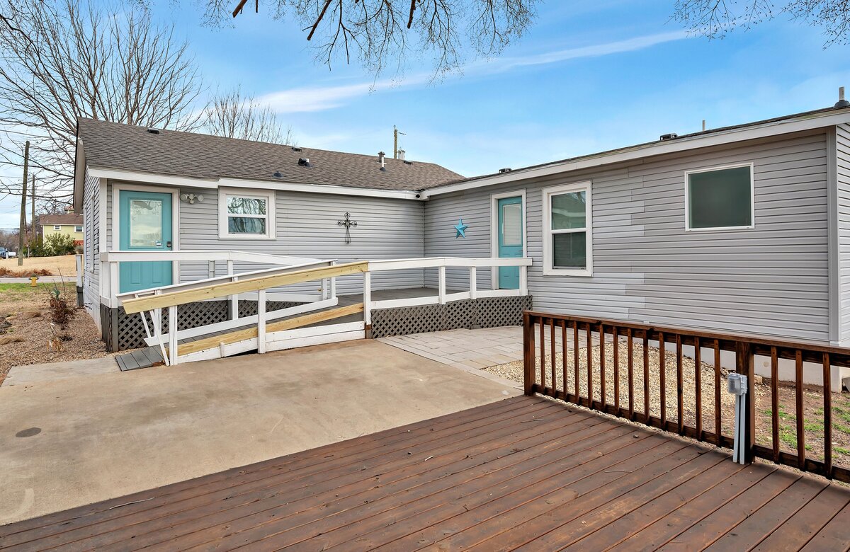 Exterior view behind the house, featuring an accessible ramp and back patio at this three-bedroom, two-bathroom vacation rental house with free Wifi, fully equipped kitchen, office space, and room for six in downtown Waco, TX.