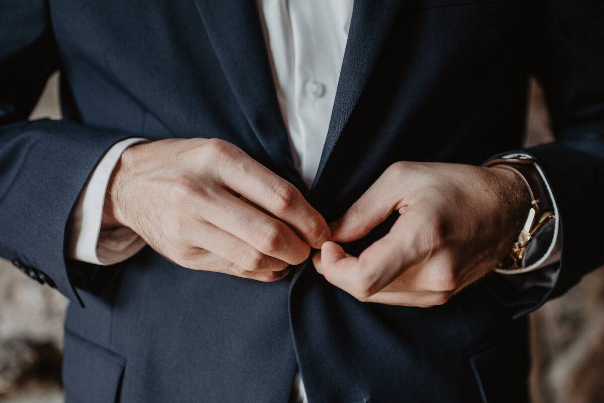 Photographers Jackson Hole capture groom buttoning jacket
