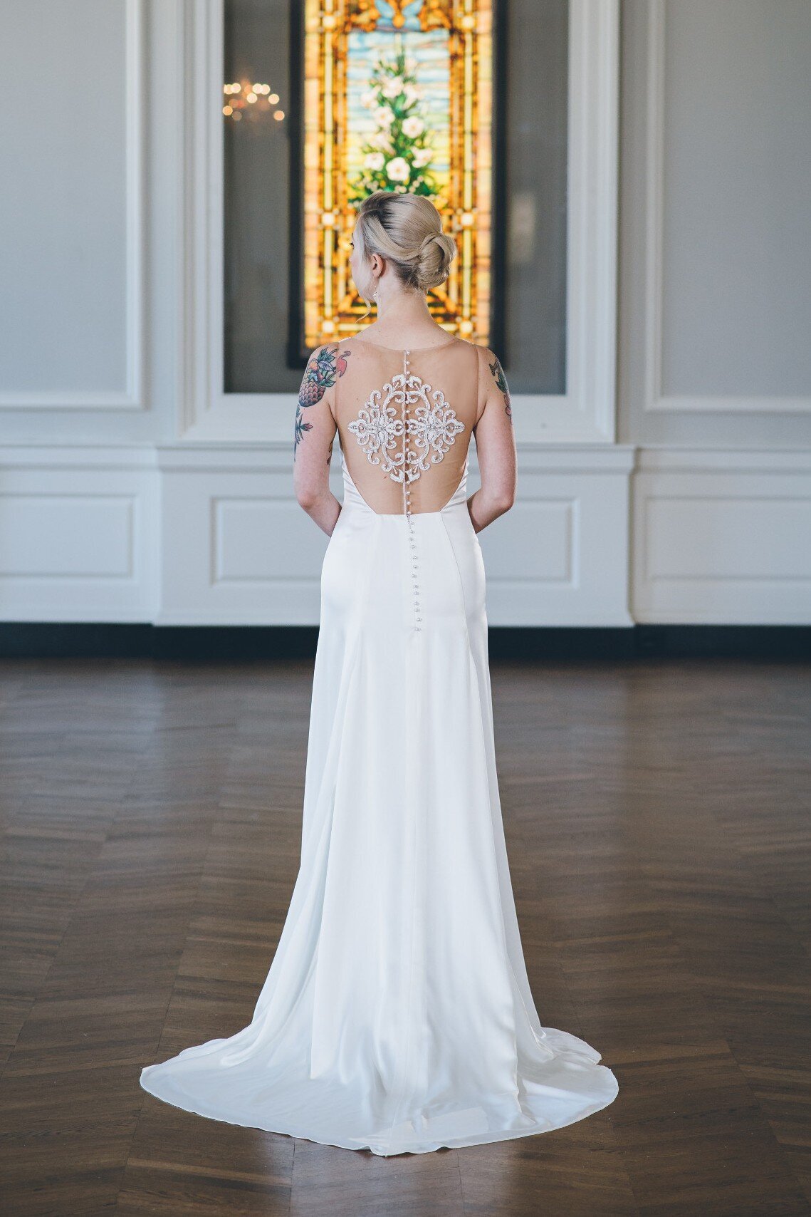 The clean lines of the skirt paired with the embroidered illusion back of the Iset style make this charmeuse wedding dress both a sexy and timeless bridal look.
