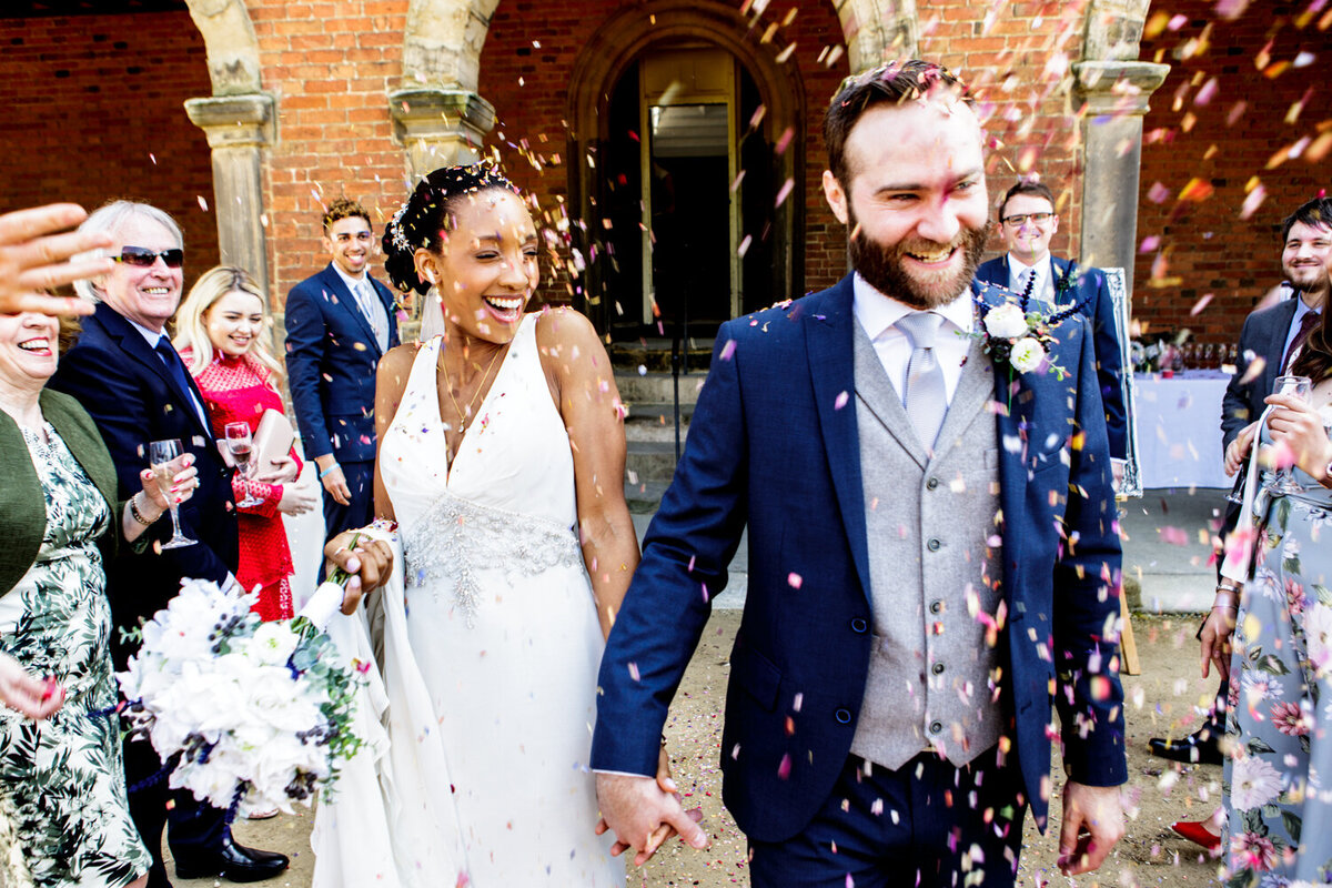 wedding couple walking through confetti tunnel