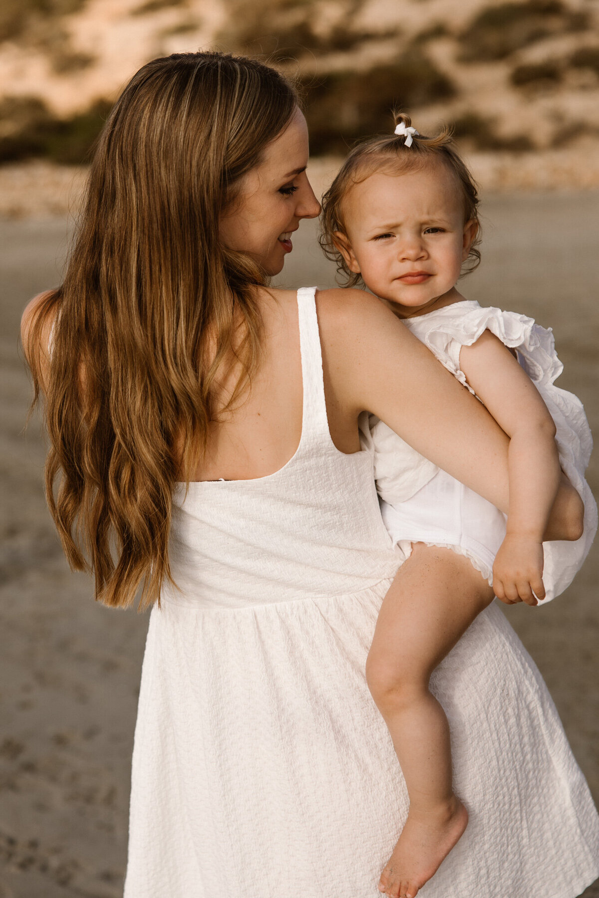 Mom is holding her daughter for a family photoshoot in Ibiza