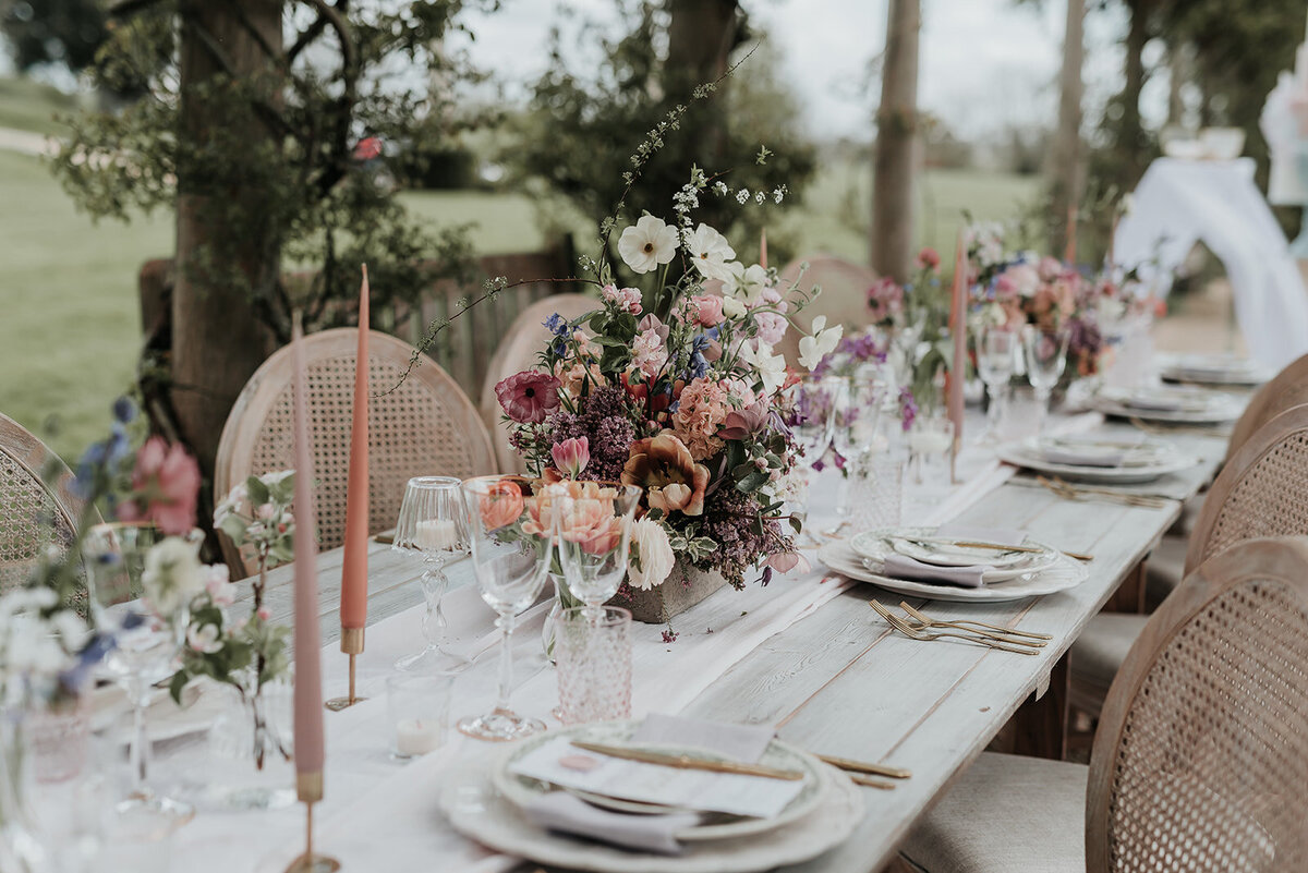 Gorgeous pastel floral centerpiece decorating a romantic wooden table at a wedding at Euridge Manor