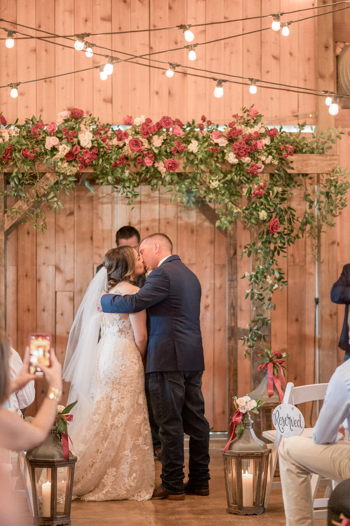 The groom wraps his arm around his new bride as they kiss.