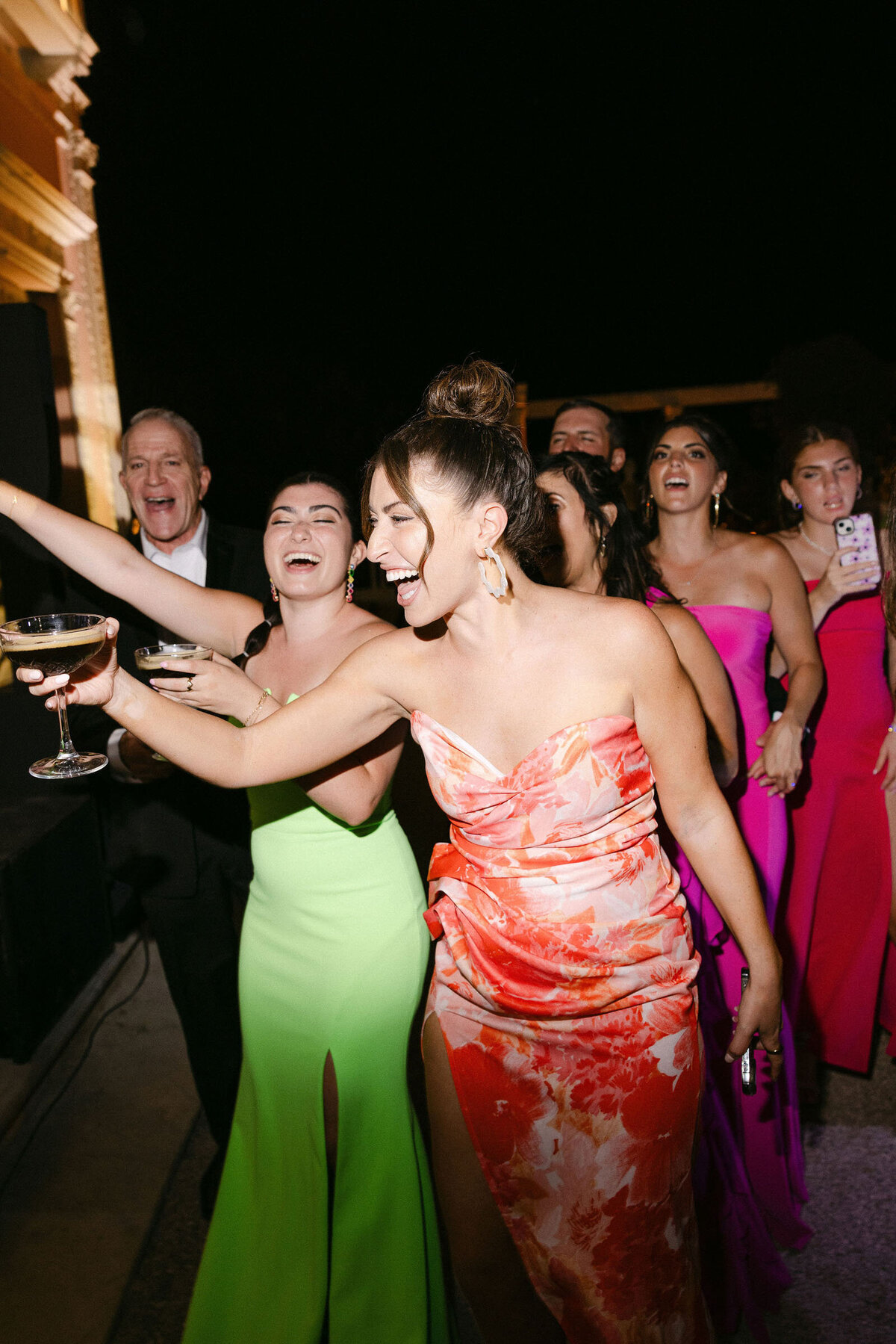 Party shot with guests laughing holding their cocktails.